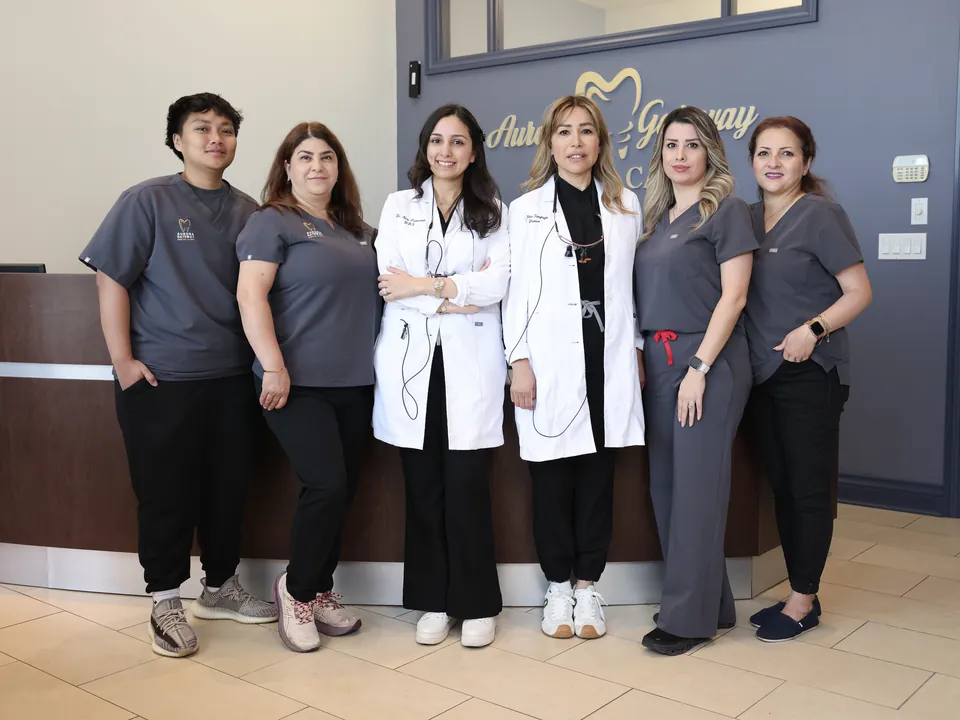 The Aurora Gateway Dental Care team standing together at the front desk