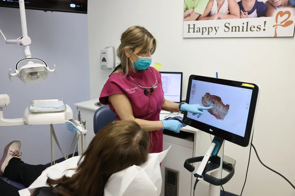 A patient's smile shown as a 3D scan on the screen