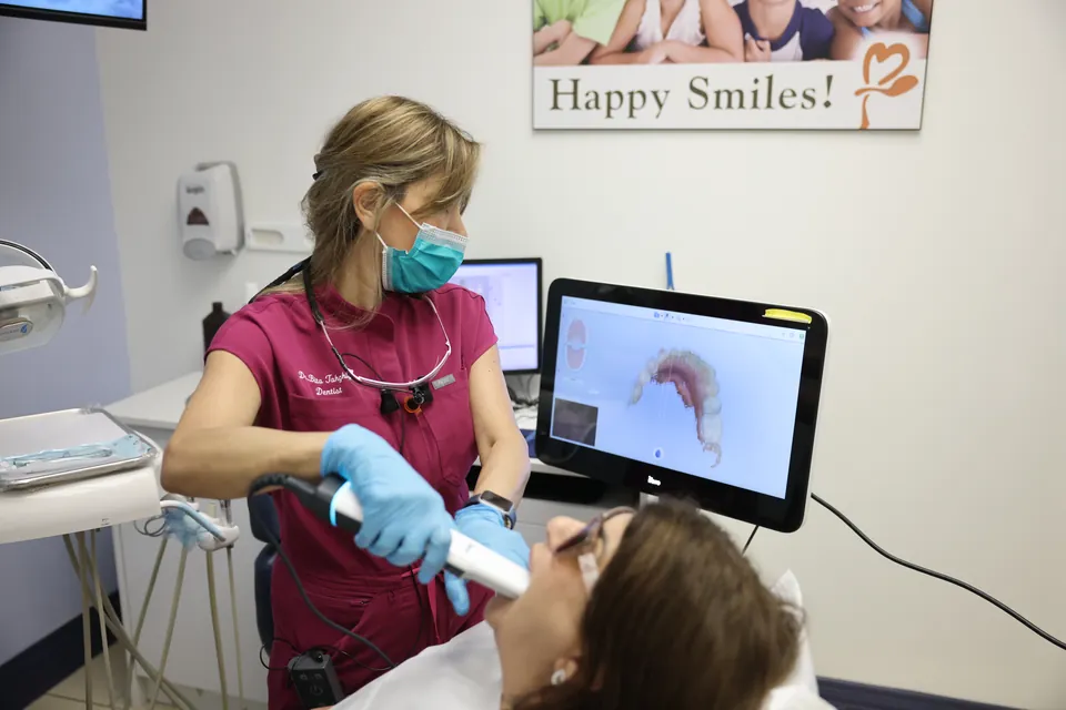 A digital impression for a crown appears on the screen beside the patient