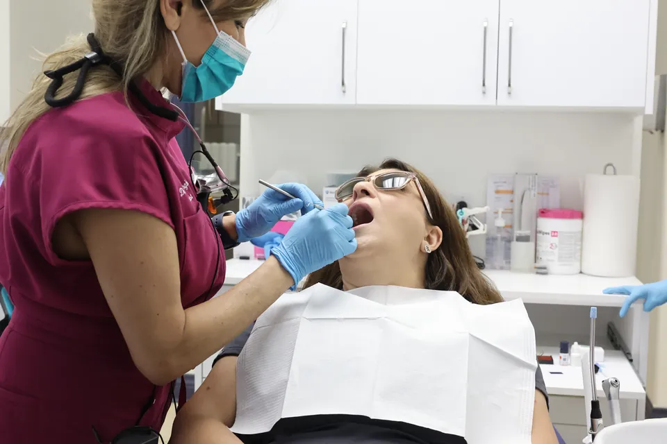 A patient has a professional cleaning in the dental chair