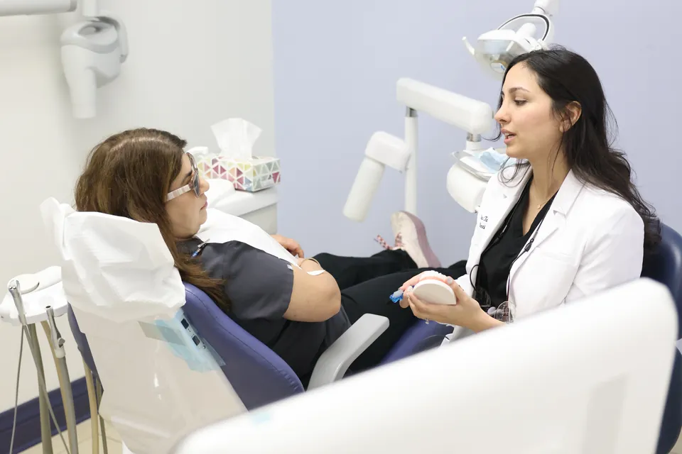 A dentist reviews an implant plan with a patient in the treatment room