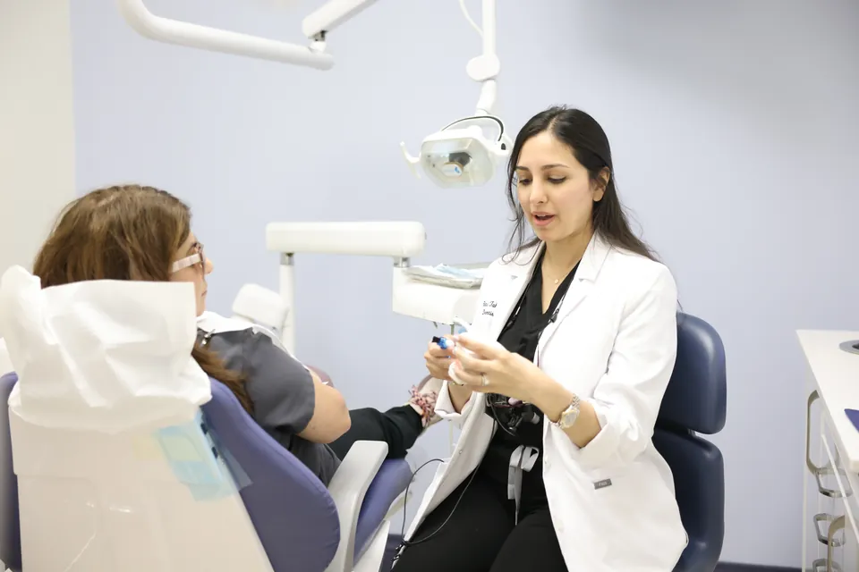 A dentist sits beside a patient and explains each step