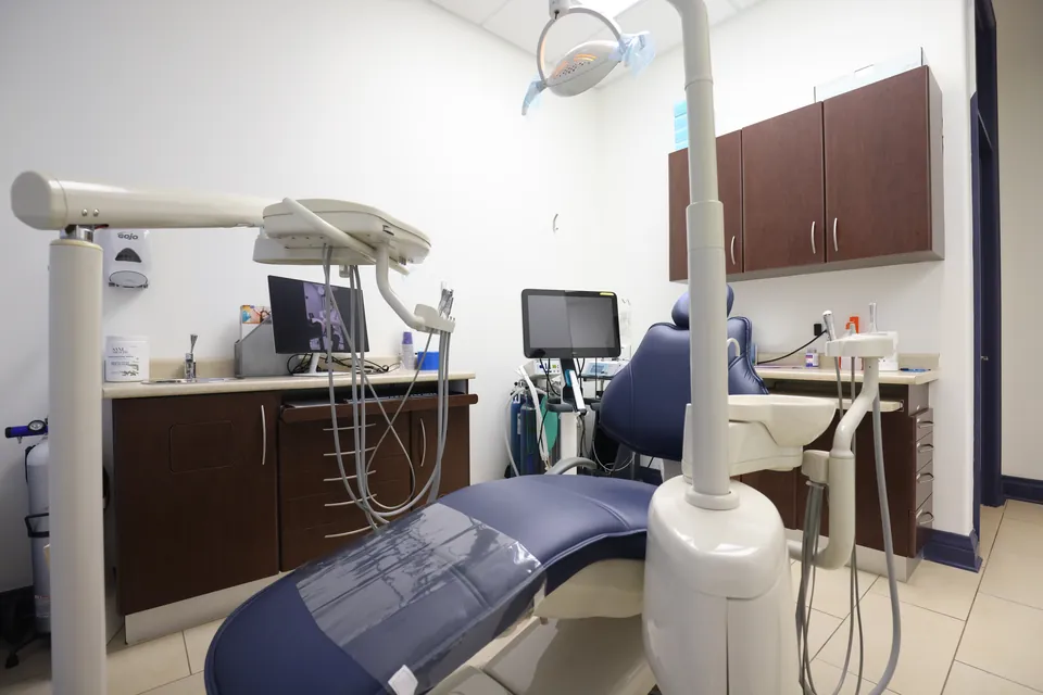 A treatment room set up with an overhead light and dental chair