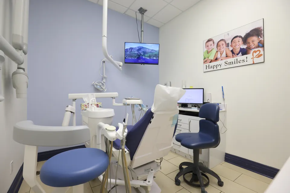 A treatment room with a children's smile poster on the wall