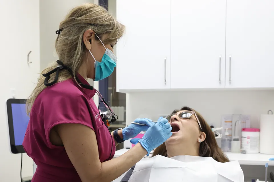 A team member checks a patient's gums
