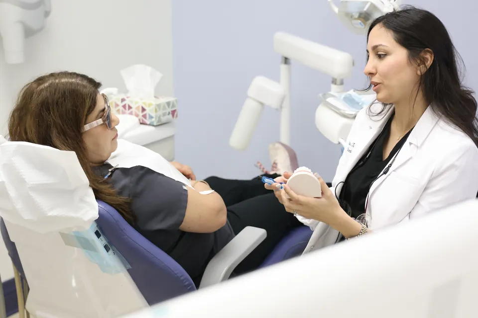 A dentist works with a patient in a bright treatment room