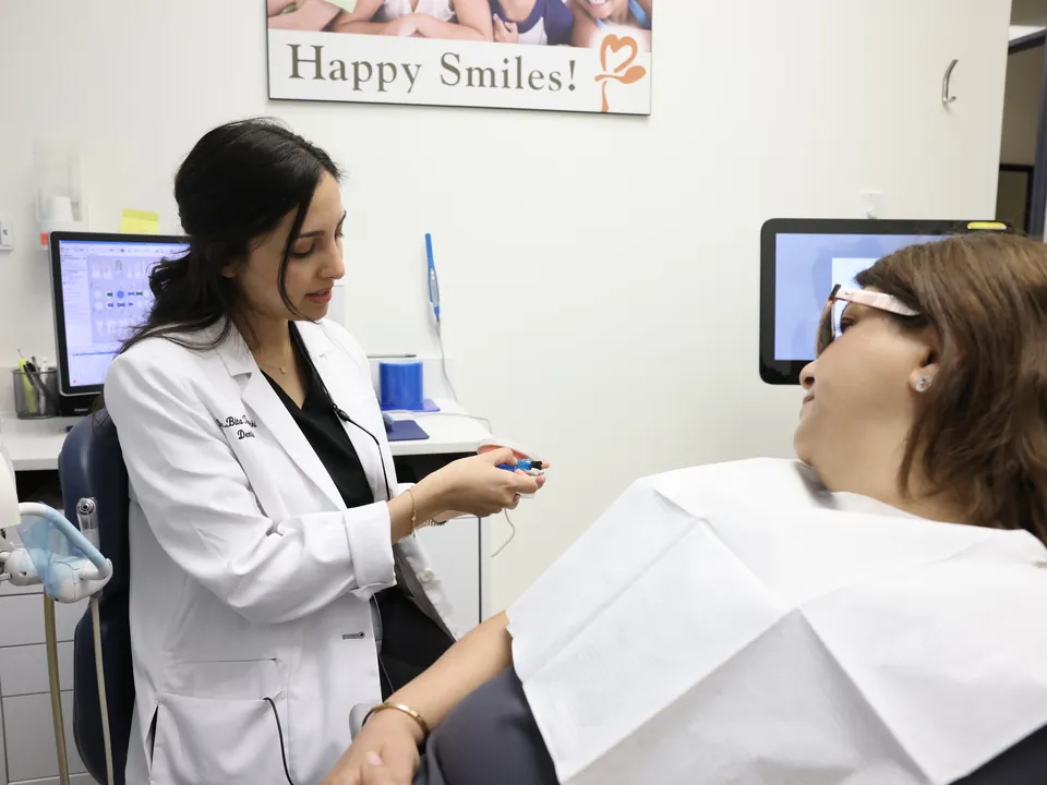 A dentist talks with a patient about her symptoms